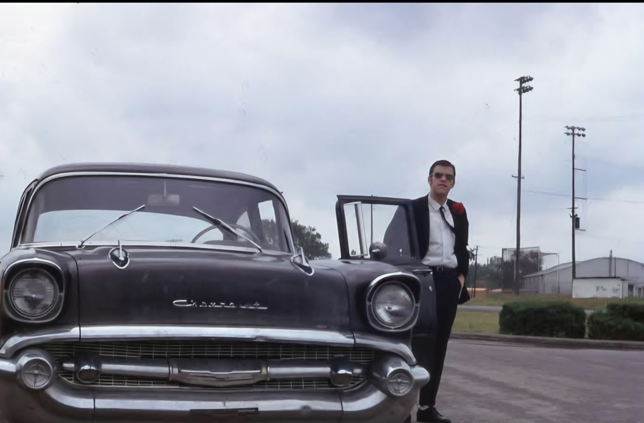 Joe Hart, founder of KWMV 88.5 FM, standing beside an old Chevrolet.